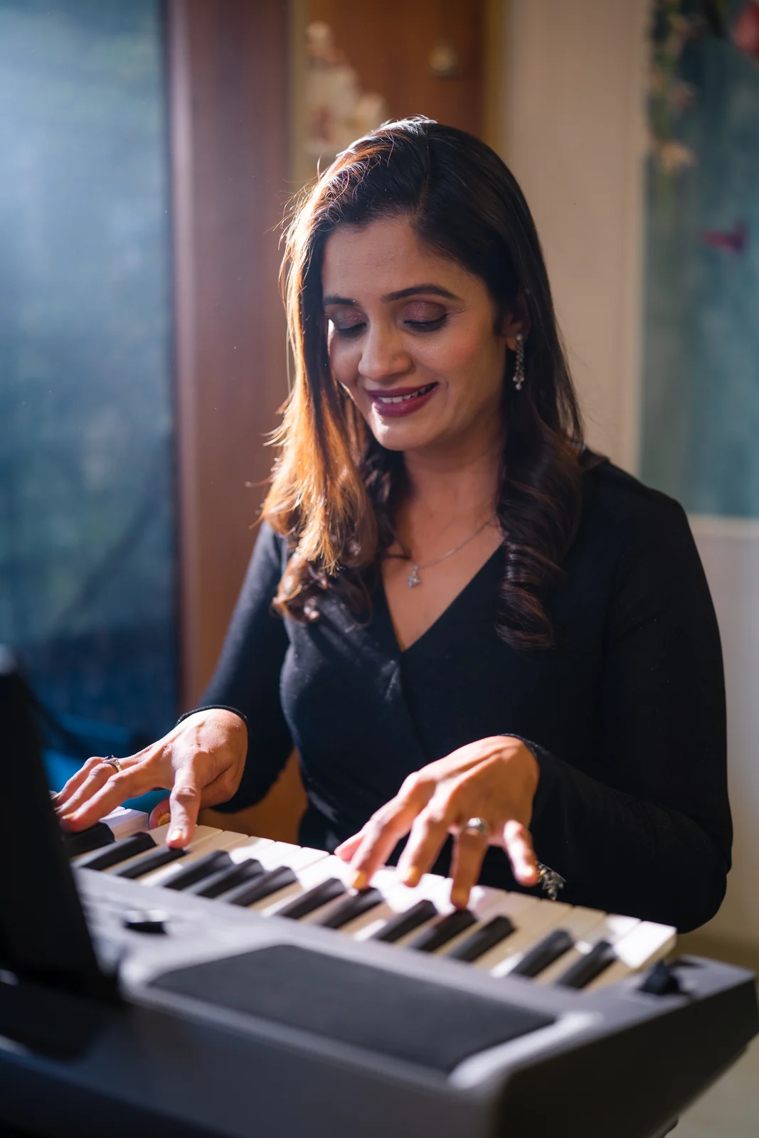 A SwarSampada musician at the keyboard during a lesson
